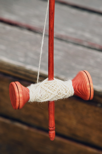 The vintage wooden spindle is a valuable tool for hand spinning and sewing enthusiasts.
