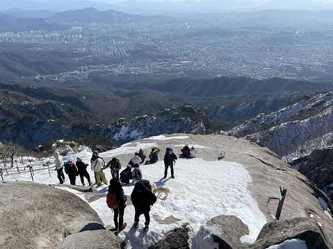 Seoul, Korea - March 1st 2024, Hikers taking a break at the Baegundae Peak, Bukhansan Mountain, Seoul Korea. 서울 북한산 백운대