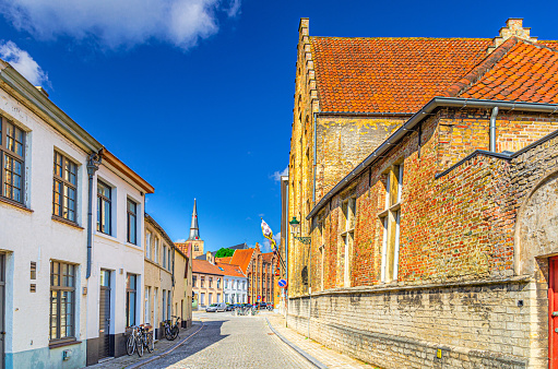 Brugge city historical centre, cobblestone street, paving stone road, buildings with brick walls and Adornes Domain museum in Bruges old town Sint-Anna quarter district, Flemish Region, Belgium