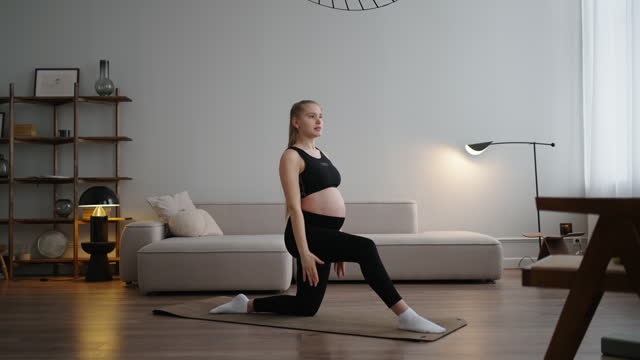Athletic Pregnant Woman Practicing Yoga In Home, Doing Stretching And Balance Exercises