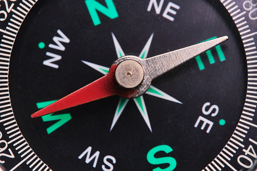 Dial compass in closeup, arrow indicates direction west