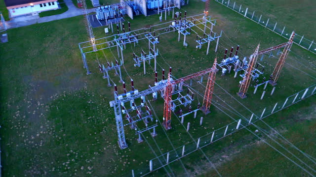 AERIAL Drone Shot of High Voltage Substation with Tall Pylons and Voltage Distribution Cables