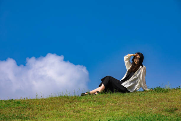 a women sitting on a grass bank in golden light