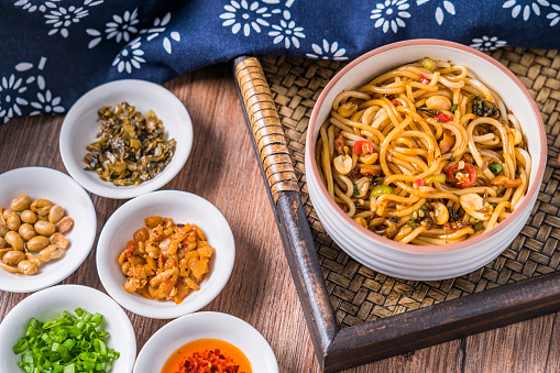 A bowl of Nanchang cuisine Nanchang mixed rice noodles placed on a wooden table in Jiangxi Province, China