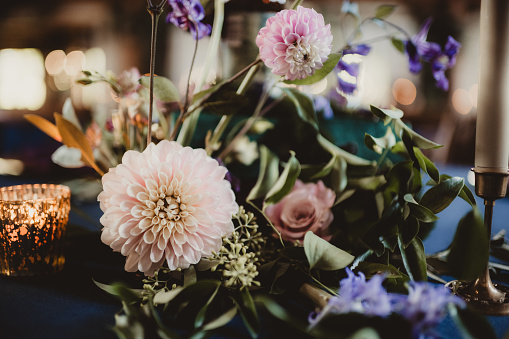 Wedding reception flower centerpiece with dahlias, roses and ranunculus