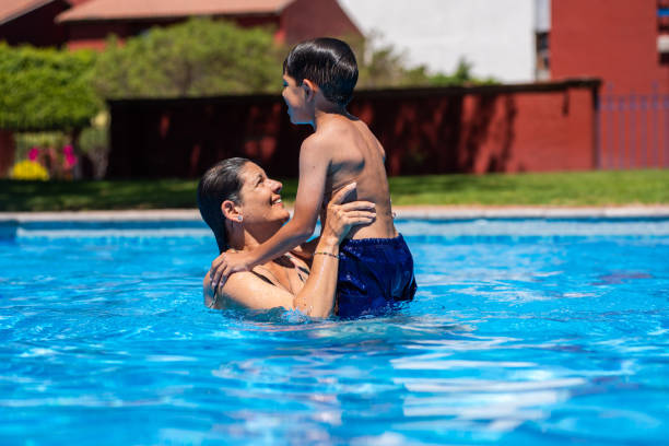 istock Mom and son playing in the pool 2070002197