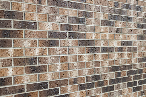 Variation in the colours and textures of a large area of clean brick wall.