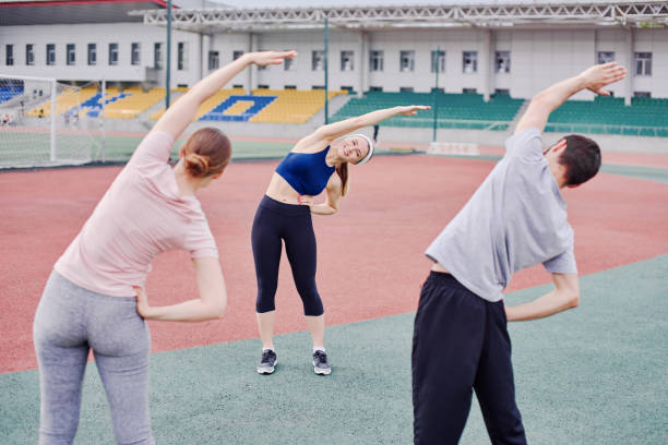istock Sportsmen doing side stretches, warming up with a trainer training 2070108066