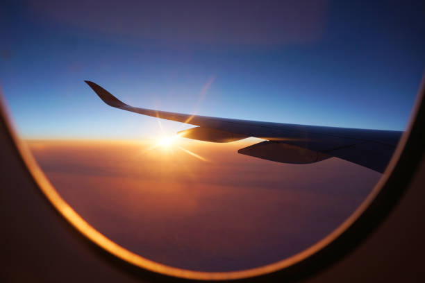 sunlight through airplane window from wing during sunrise