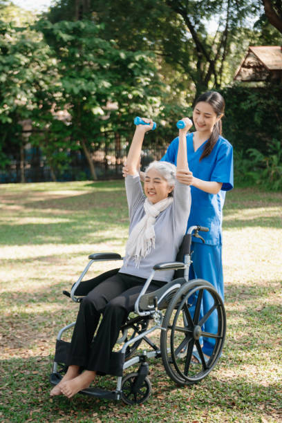 istock Asian physiotherapist helping elderly woman patient stretching arm during exercise correct with dumbbell in hand during training hand with patient Back problems in the garden. 2070235194