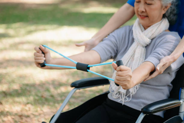 istock Asian physiotherapist helping elderly woman patient stretching arm during exercise correct with dumbbell in hand during training hand with patient Back problems in the garden. 2070235198