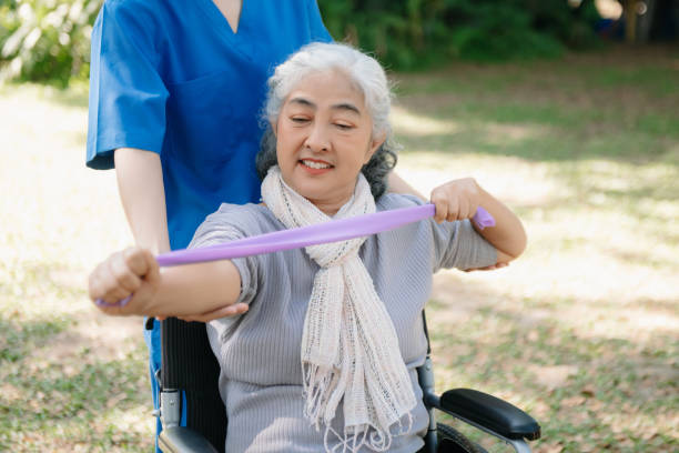 istock Asian physiotherapist helping elderly woman patient stretching arm during exercise correct with dumbbell in hand during training hand with patient Back problems in the garden. 2070235200