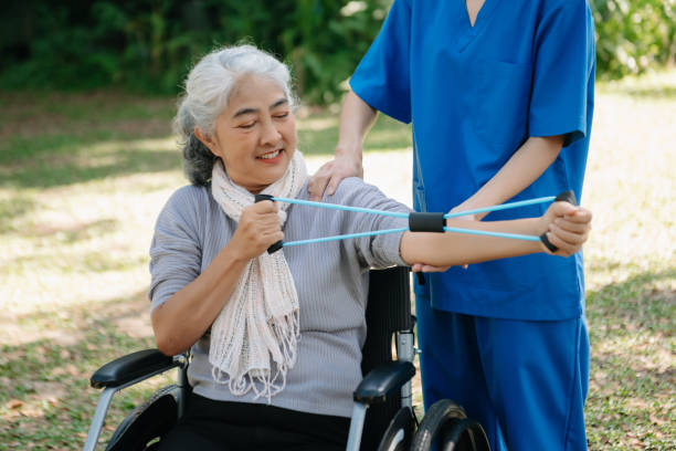istock Asian physiotherapist helping elderly woman patient stretching arm during exercise correct with dumbbell in hand during training hand with patient Back problems in the garden. 2070235203