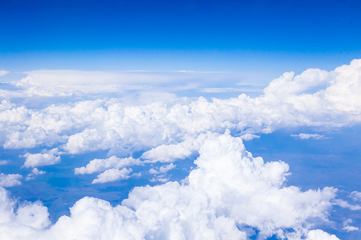 Cumulus white clouds and blue sky from the height of an airplane.
