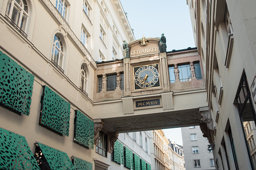 Vienna, Austria - June 13, 2013: Ankeruhr - decorative clock in a bridge between the two parts of the Anker Insurance Company‘s building. Art Nouveau styled clock in a bridge over narrow street.