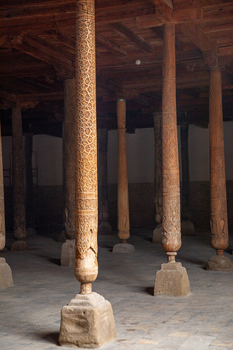 many number of wooden beams with the highly carved in hands inside a historical place, Khiva, the Khoresm agricultural oasis, Citadel.