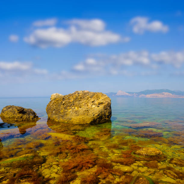 sea bay with huge stones on coast under blue cloudy sky