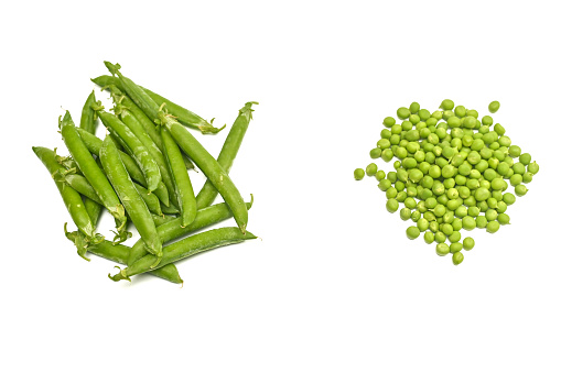 pods of fresh peas and a bunch of peeled peas. isolated