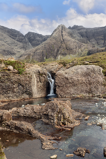 The Fairy Pools of Skye invite exploration with their tranquil waters and dramatic mountainous backdrop, offering a glimpse into Scotland's wild beauty (Vertical photo)