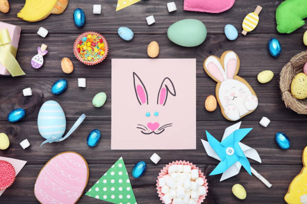 istock Easter gingerbread cookies with greeting card, eggs, sprinkles and paper windmill on brown wooden table 2070528191