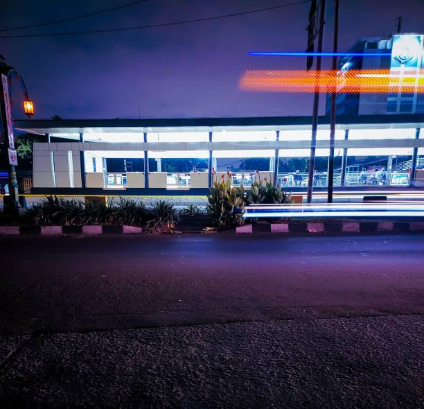 Nighttime photo at one of the Transjakarta bus stops in Jakarta, Indonesia. Experience the vibrant city lights and the hustle and bustle of urban life captured in this stunning shot.