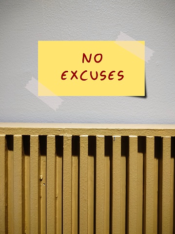 Stick note on wall written NO EXCUSES - concept of Living in present /doing right now, no procrastination anymore