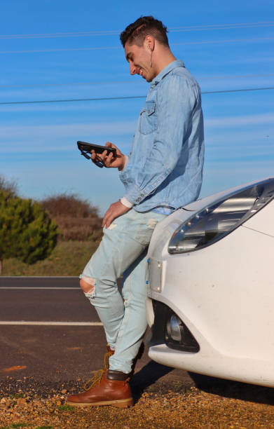 istock Curly haired Caucasian man leaning on his car 2070562318