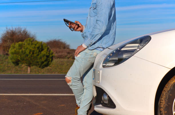 istock Curly haired Caucasian man leaning on his car 2070565415
