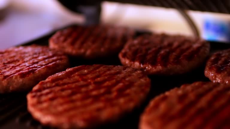 hamburger patties on an electric grill. There is a grill in the kitchen