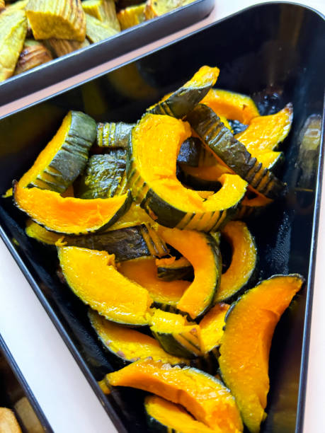 Full frame image of hotel self service refrigerated buffet display, salad bar metal tray of chopped pumpkin slices, ingredients for self made salad, salad vegetable restaurant buffet, elevated view