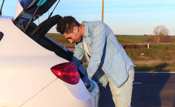 istock Curly haired Caucasian man looking for something in the trunk 2070576740