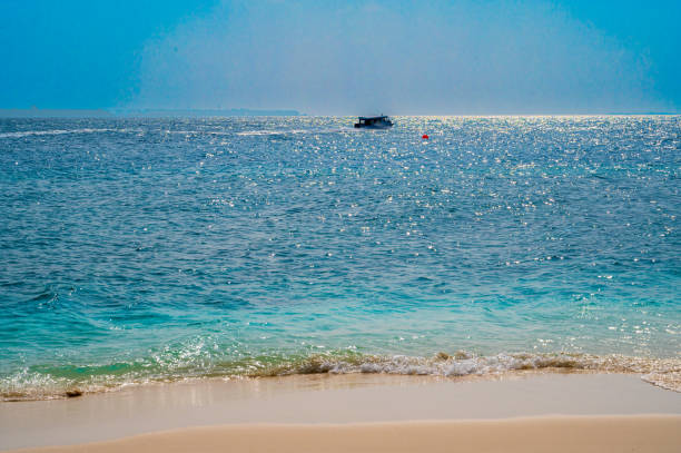 White boat floats fast on the surface of the sea. Sunny weather.