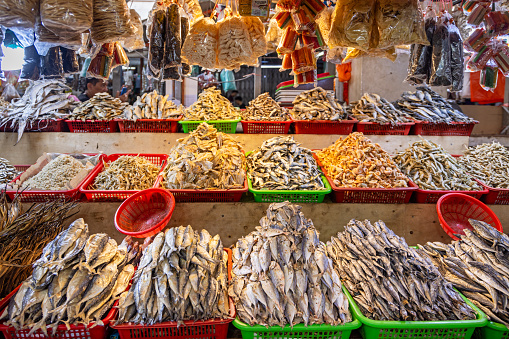 Dried sea fish hanging on hooks at a local fish market.