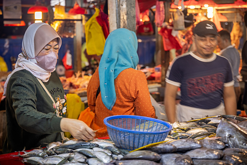 Chow Kit market, Kuala Lumpur, Malaysia - January 10th 2024:  Customers at a fishmongers stall in the famous food market in the center of the capital