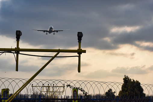 Airplane landing at the airport runway at sunset
