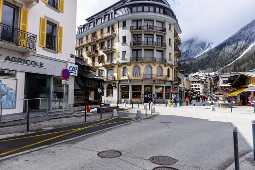 Chamonix-Mont-Blanc, France - April 1, 2018 : Central street with cafes and stores in Chamonix with tourists walk in town. Chamonix is one of the oldest ski resorts in France.