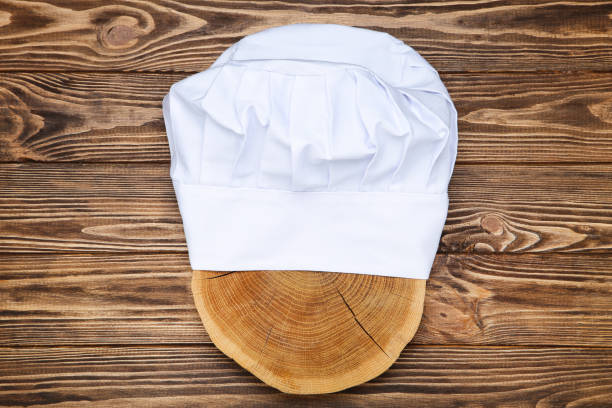 istock Chef hat with cutting board on wooden background 2070666604
