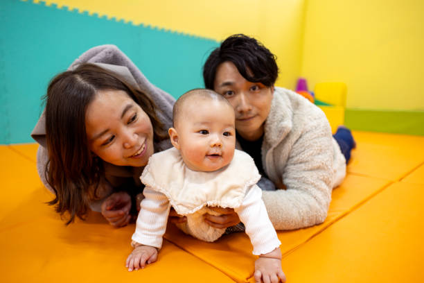 Father and baby son playing on colorful floor