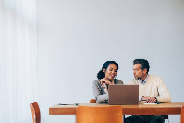 istock Professional Colleagues Discussing Work on a Laptop in Modern Office 2070679192