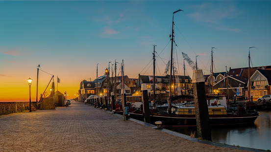 Urk Flevoland Netherlands sunset at the lighthouse and harbor of Urk Holland. Traditional Fishing village Urk. Beautiful sunset during the evening