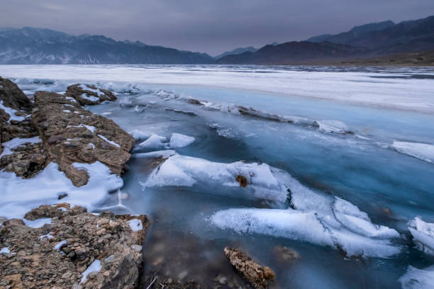 istock A harsh mountain lake with rocks, covered with ice, snow and hummocks in early spring. Bartogay reservoir in Kazakhstan. 2070709050