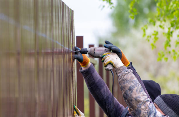 Workers install a metal profile fence
