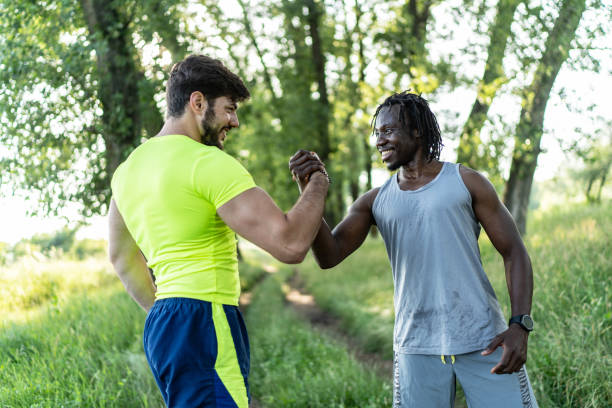 istock Two joggers greeting each other with a high five gesture during summer workout in nature 2070739137