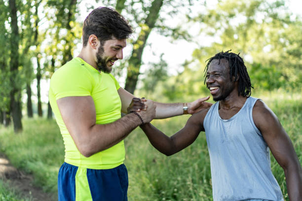 istock Two joggers greeting each other with a high five gesture during summer workout in nature 2070741509