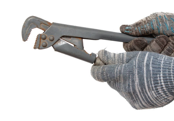 istock Plumber's hand in glove holding a pipe wrench isolated on white background 2070791633