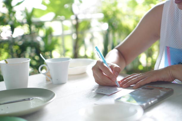 istock Business woman checking documents or note working for home with smartphone on table or reminder planner note in bill payment 2070800630