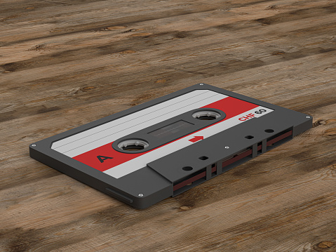 Cassette tape on a wooden background. 3d illustration.