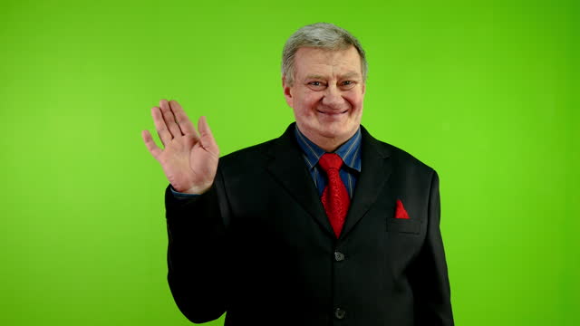 Friendly senior businessman waves palm for greeting or goodbye sign.