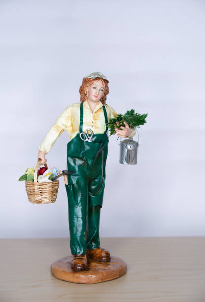 view figurine Gardener in uniform, with watering can and basket with flowers