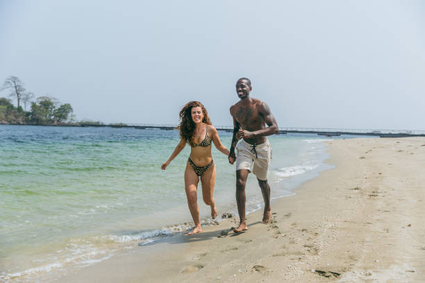 istock An interracial couple has fun on the beach during vacation 2070840182